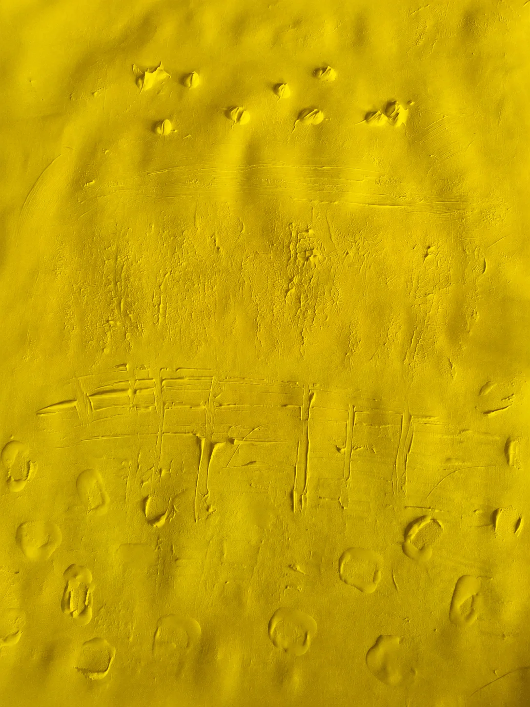 Yellow textured artwork with layered marks